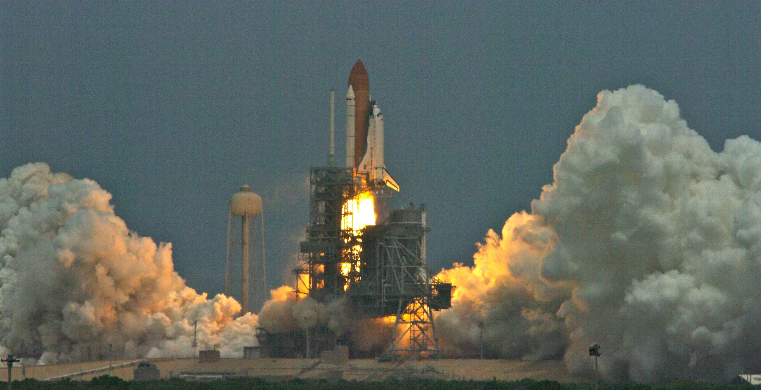 Launch of STS-125 for Final Hubble Servicing Mission. space shuttle lauching with large plumes of smoke to the left and right