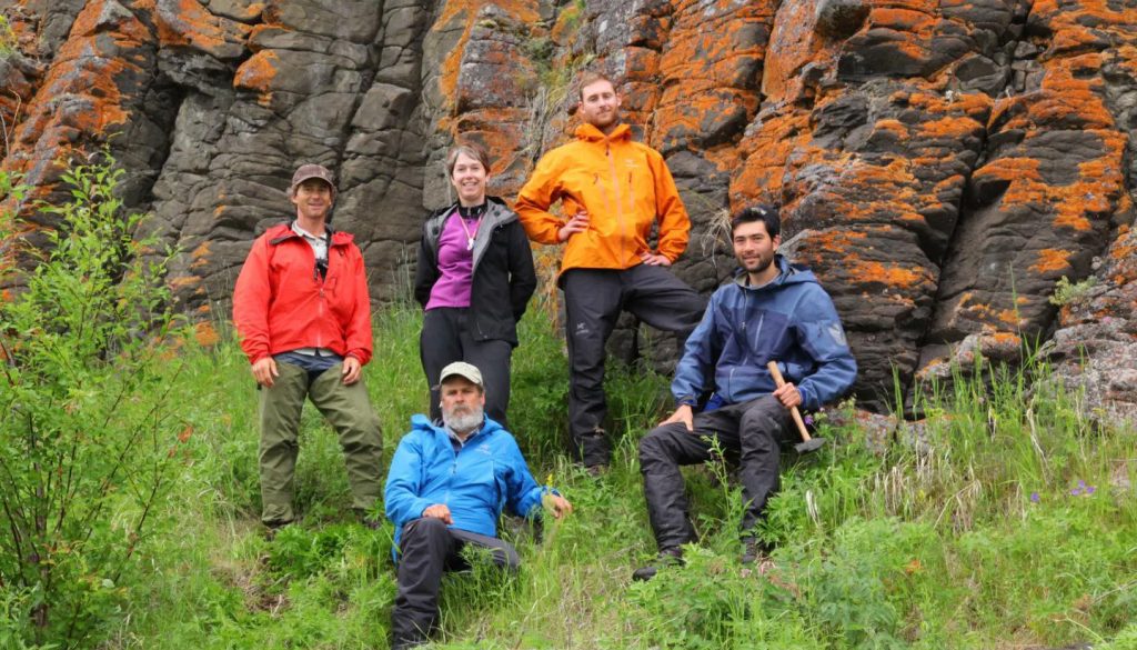 Lindy Elkins-Tanton, in purple blouse, with team members in Siberia, where they were studying basaltic lava erupted 250 million years ago. With Elkins-Tanton are, counter-clockwise from upper left, Scott Simper, Sam Bowring, Ben Black and Seth Burgess. They are standing in front of columnar basalt on an island in the Angara River in Siberia.